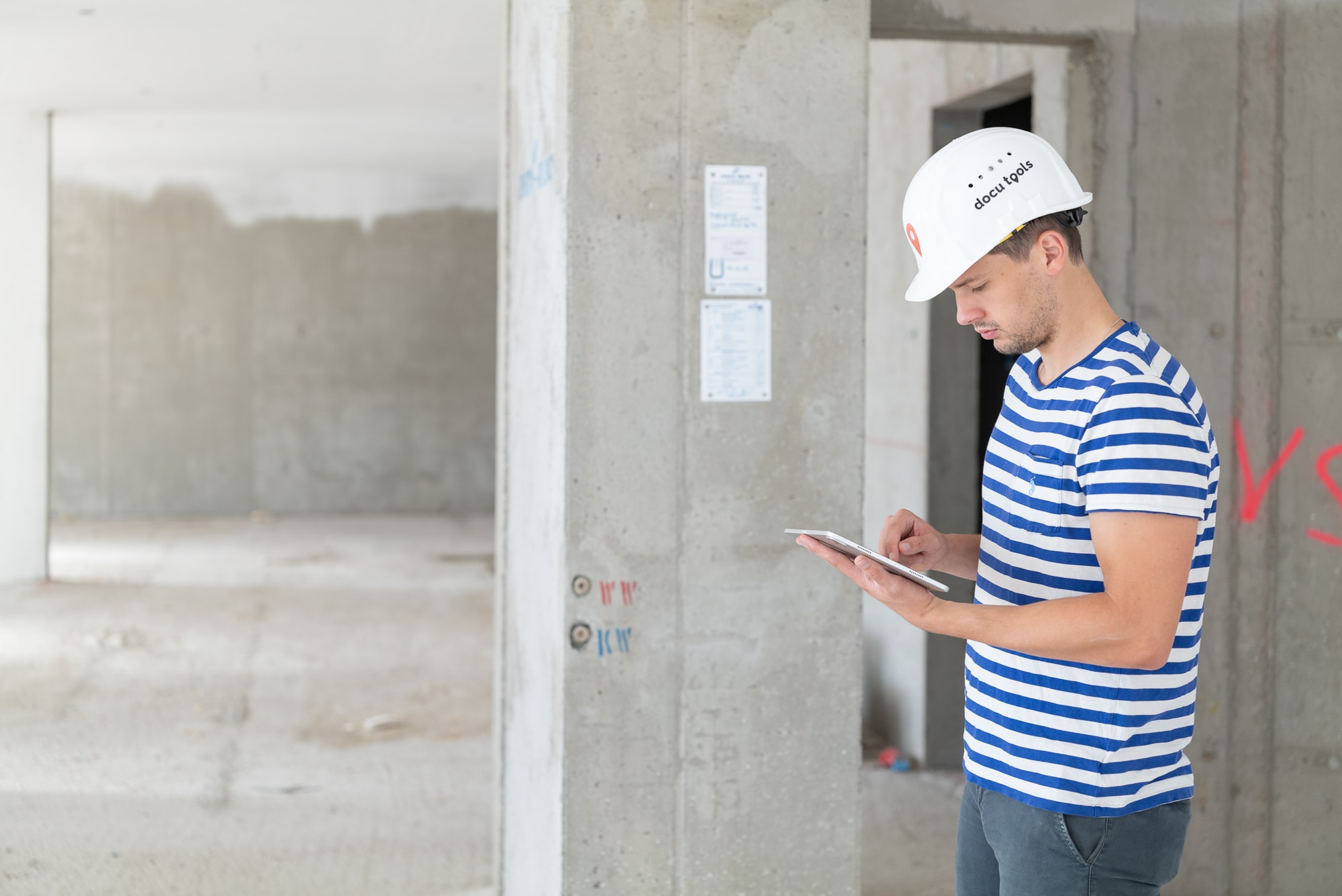 Digitale Bauabnahme: Bauleiter prüft Leistungen und dokumentiert Abnahmepunkte mit Tablet direkt auf der Baustelle.