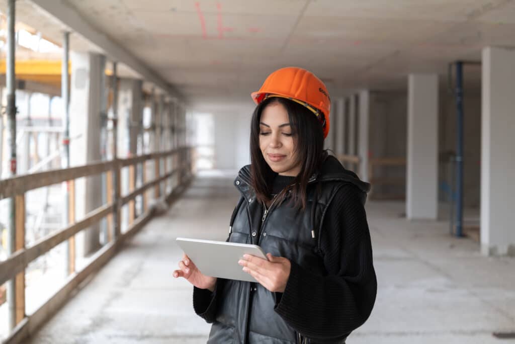 Mitarbeiterin von docu tools nutzt Tablet zur digitalen Baudokumentation auf einer Baustelle.